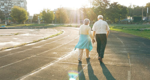 Senior couple holding hands while taking a walk.