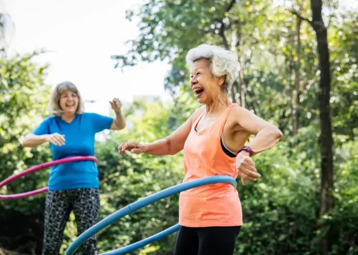 Senior woman exercising with a hula hoop