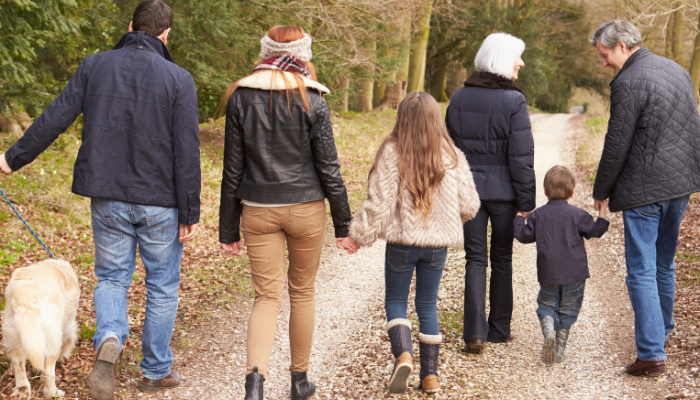 Multigenerational family taking a walk on an autumn day. 