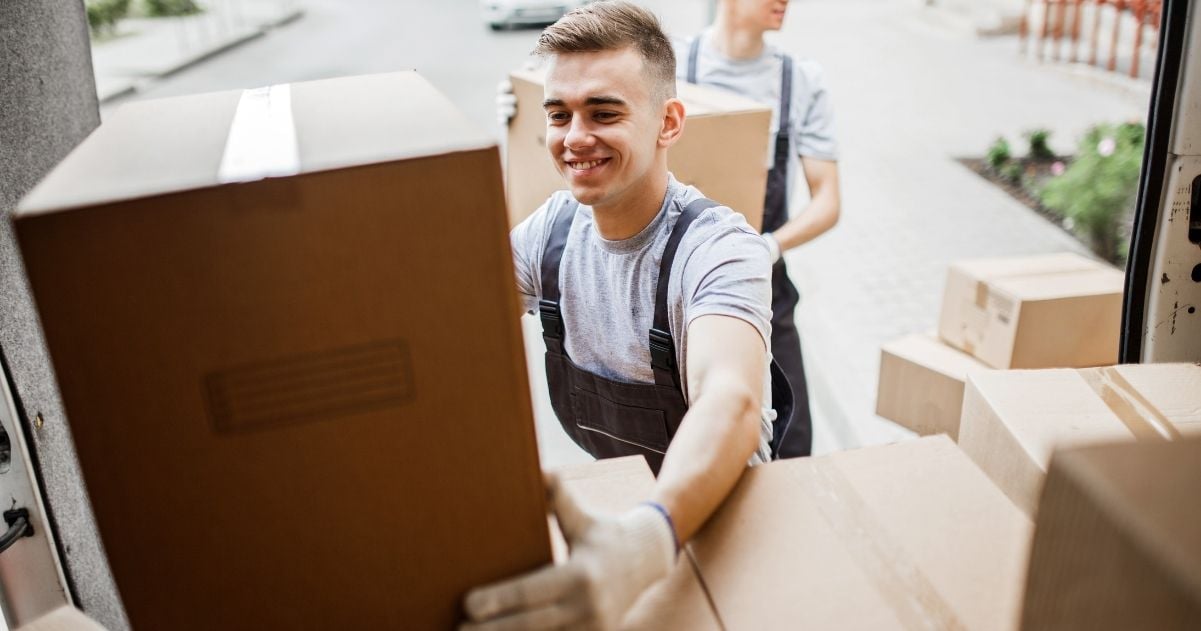 Professional movers loading packed boxes into a truck.