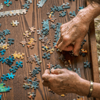 Adult with Alzheimer’s doing a puzzle.