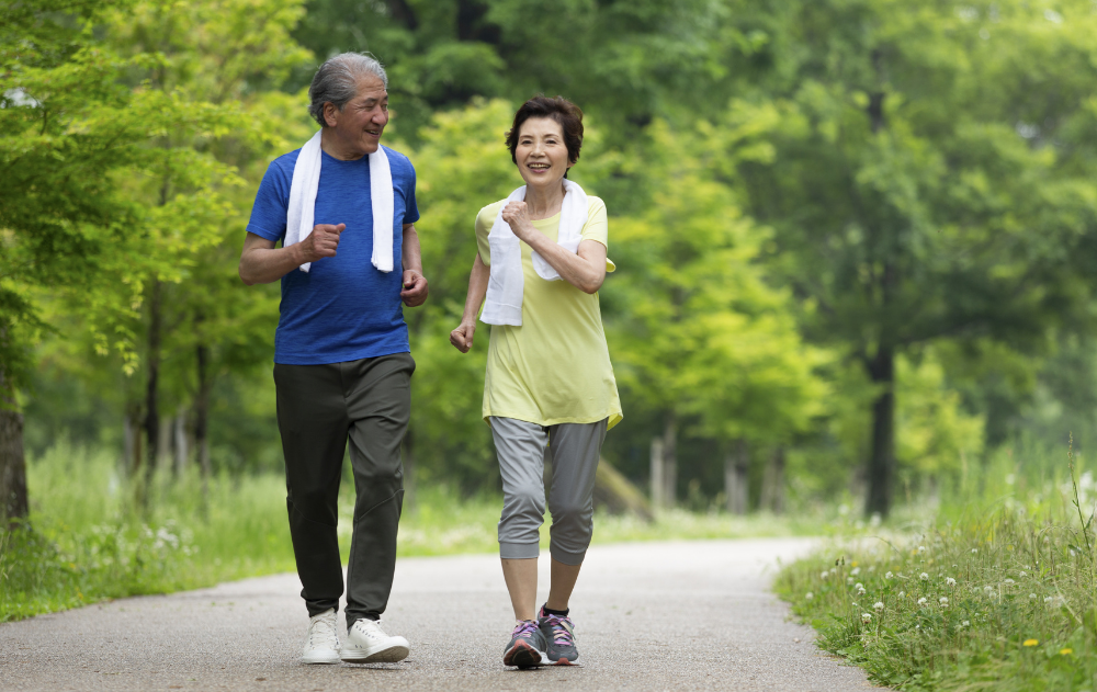 Multi ethnic seniors outdoors power walking on a walking path.