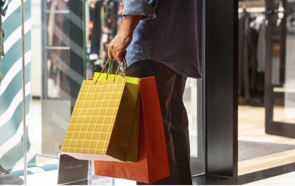 senior man shopping while carrying multiple shopping bags