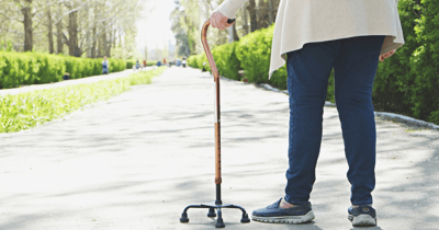 Senior going on a walk and using a cane for assistance.