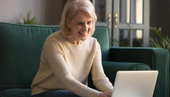 Smiling mature woman chats with friends during a virtual get-together