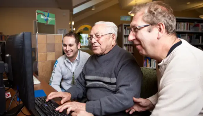 Mature man with his son and grandson learning how to use social media