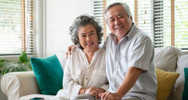 Mature man and woman sitting on a sofa together.