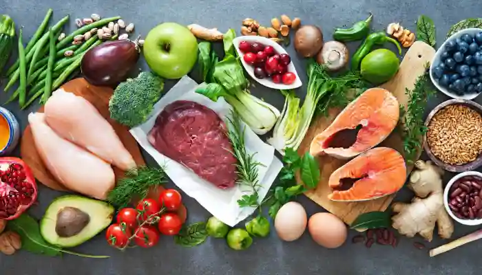 Flatlay of nutritious foods including salmon, vegetables, and fruits
