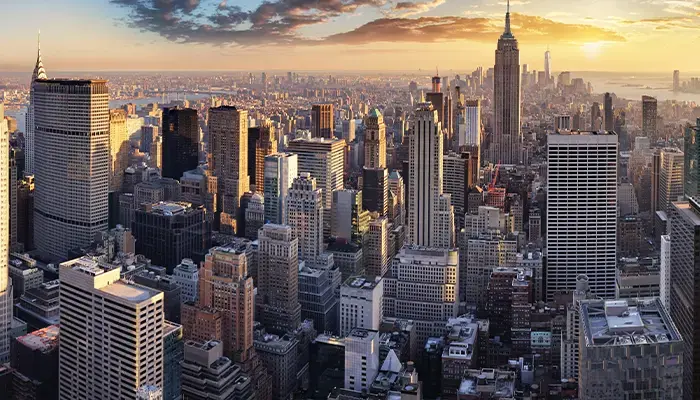 Aerial view of the New York City skyline at sunset, featuring the Empire State Building and surrounding skyscrapers