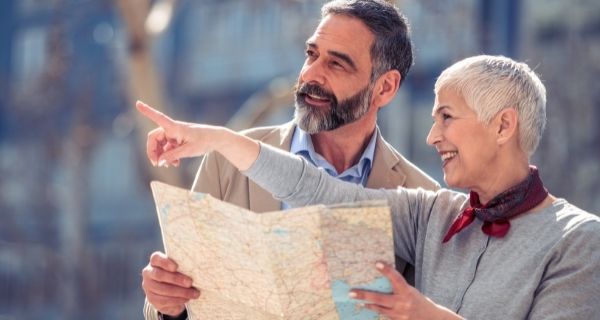 Senior couple finding a location on a map while taking a trip together.