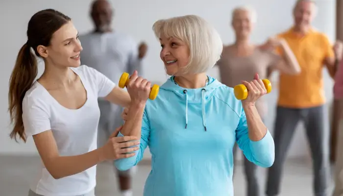 Senior woman at a fitness class with help from an instructor