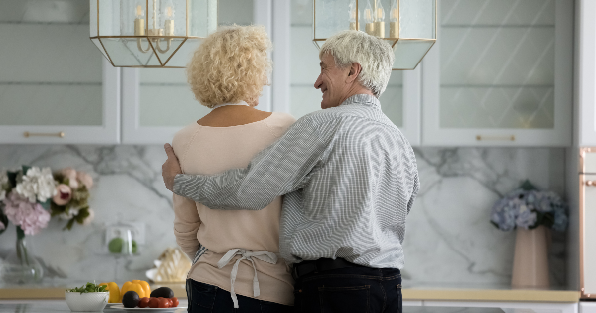 Senior man and woman in their luxury kitchen discussing memory care for a loved one.