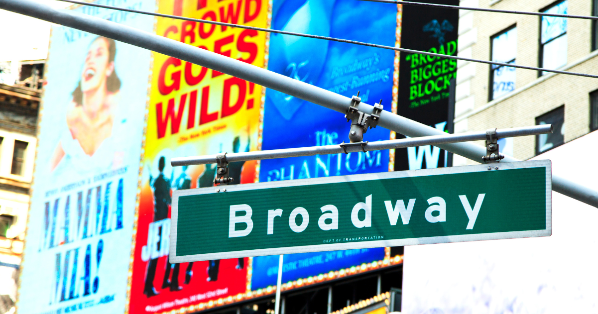 Broadway street sign in front view of theater advertisements in New York, New York